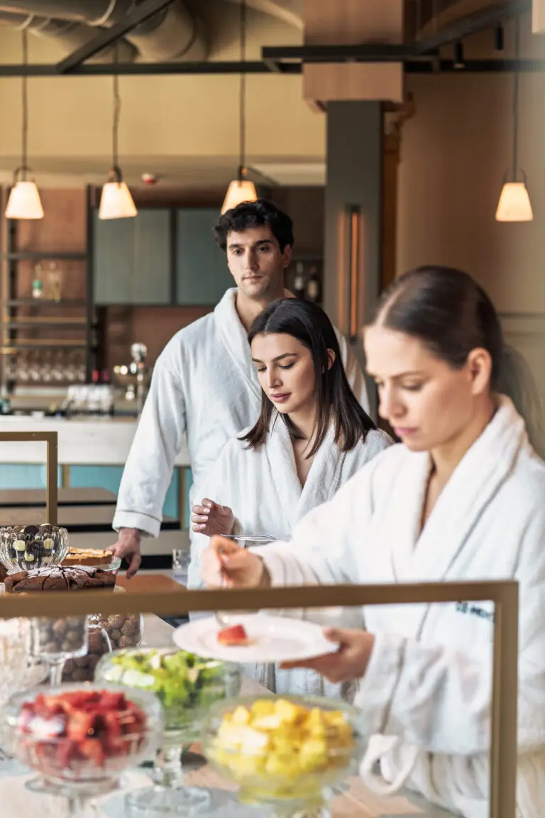People in dressing gowns selecting fruit during a wellness-focused buffet lunch