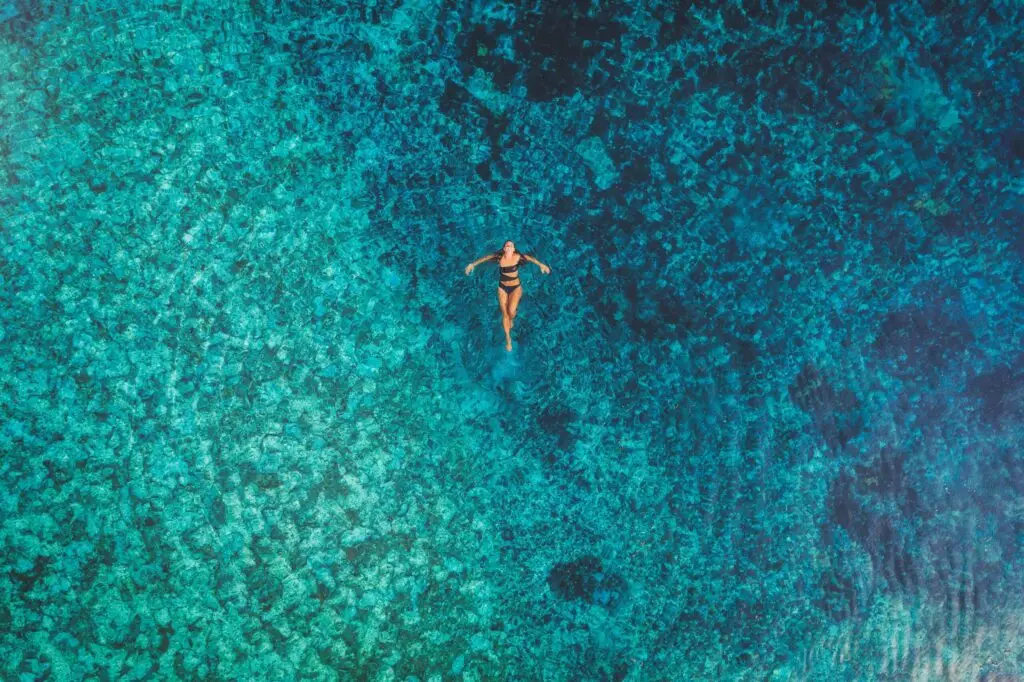 Woman floating in crystal clear turquoise water