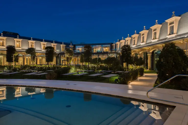 Cortile di un hotel di lusso con piscina di notte, perfetto per eventi.