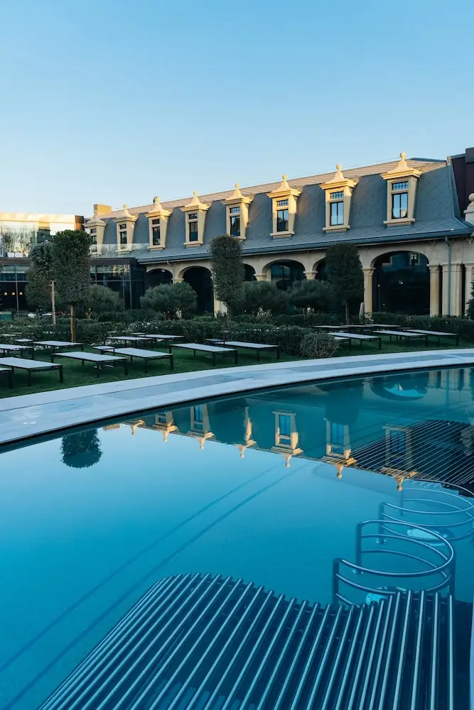 La piscina all'aperto del De Montel Terme Milano riflette l'edificio.